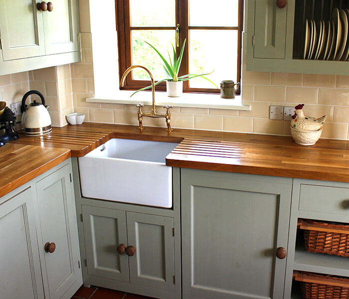 Traditional kitchen with gray cabinets and butcher block countertop.