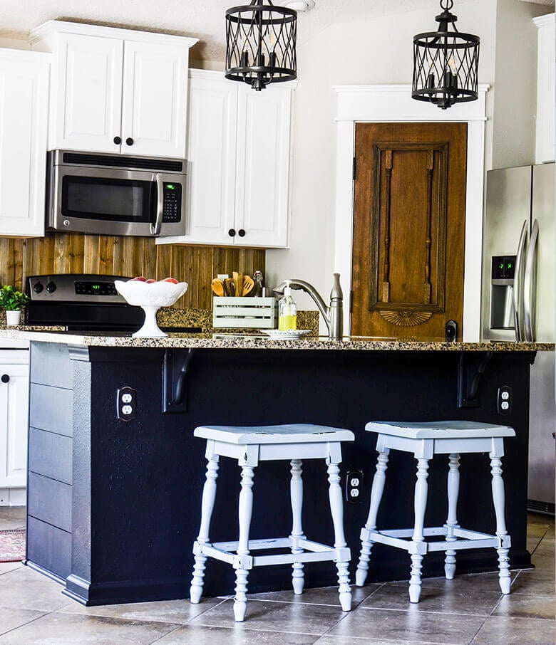 Traditional kitchen with white shaker cabinets and dark blue kitchen island.
