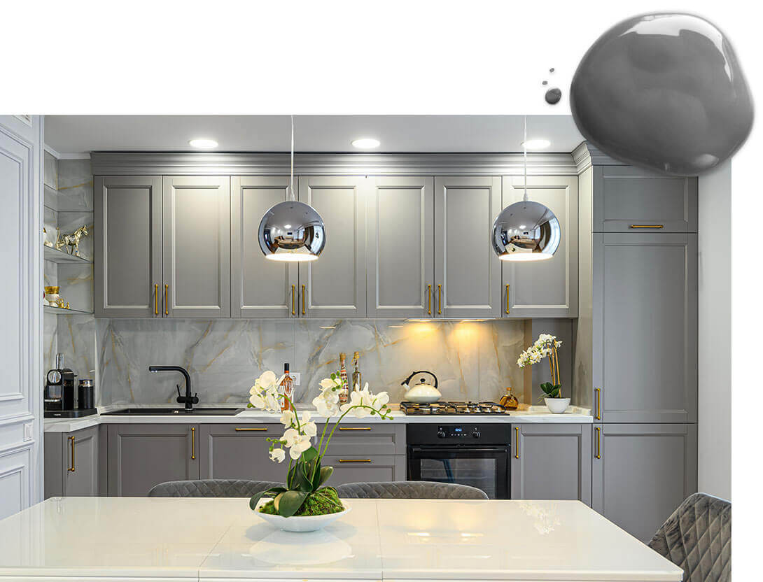 Kitchen with light gray painted cabinets with modern copper hardware and two polished silver pendant lights.