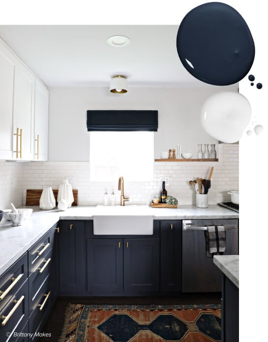 Kitchen with white upper cabinets and navy blue lower cabinets with modern gold hardware and subway tile backsplash.