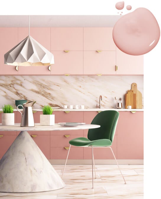 Kitchen with soft pink painted cabinets, gold half-moon hardware and marble countertops and dining table.