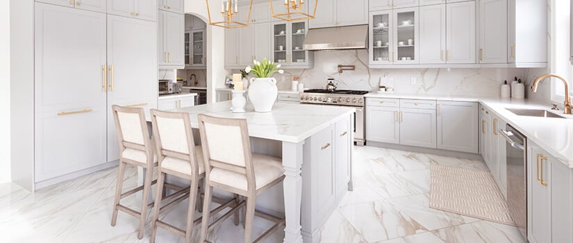 Marble floors with white cabinets, granite countertops, stainless steel appliances, and gold accents.