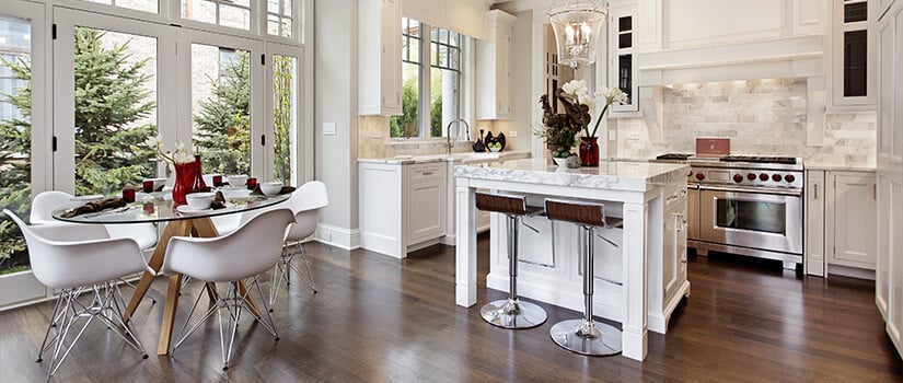 Traditional style kitchen with hardwood floors, white cabinets, and granite countertops.