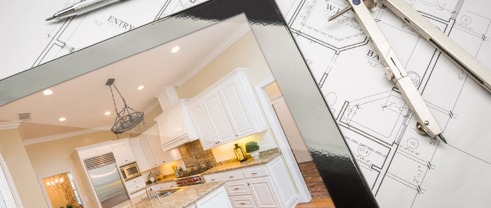 Tablet displaying white updated kitchen placed on top of kitchen blueprints.