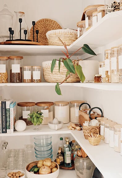 Organized boho pantry with glass containers.