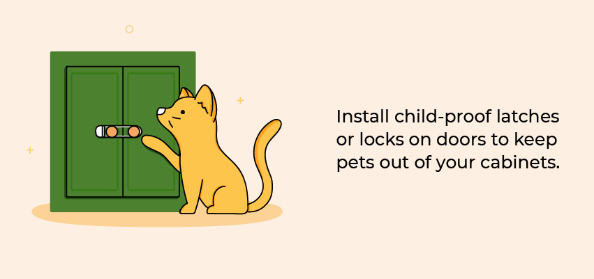 Cat trying to open a cabinet door with a child lock on it.