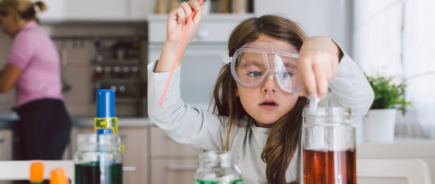 Little girl doing science experiments in the kitchen.