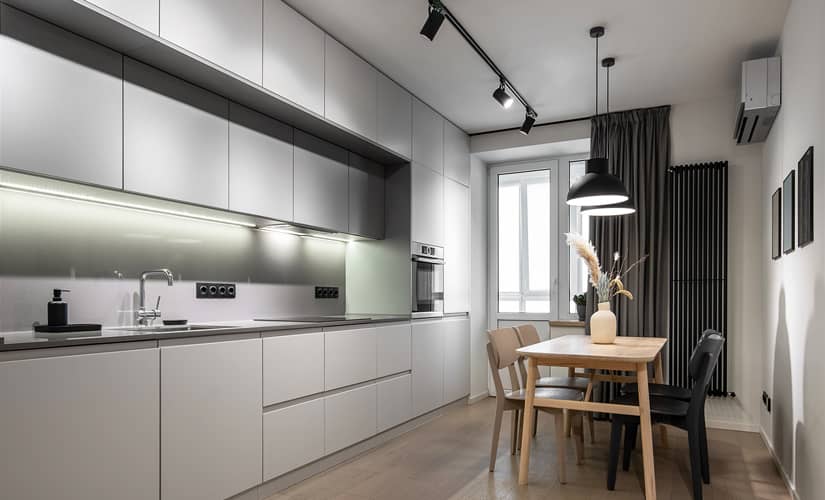A modern gray kitchen with track and pendant lights