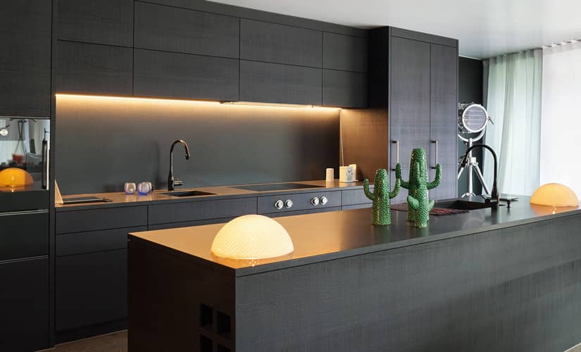 A black kitchen with counter lights and kitchen decor