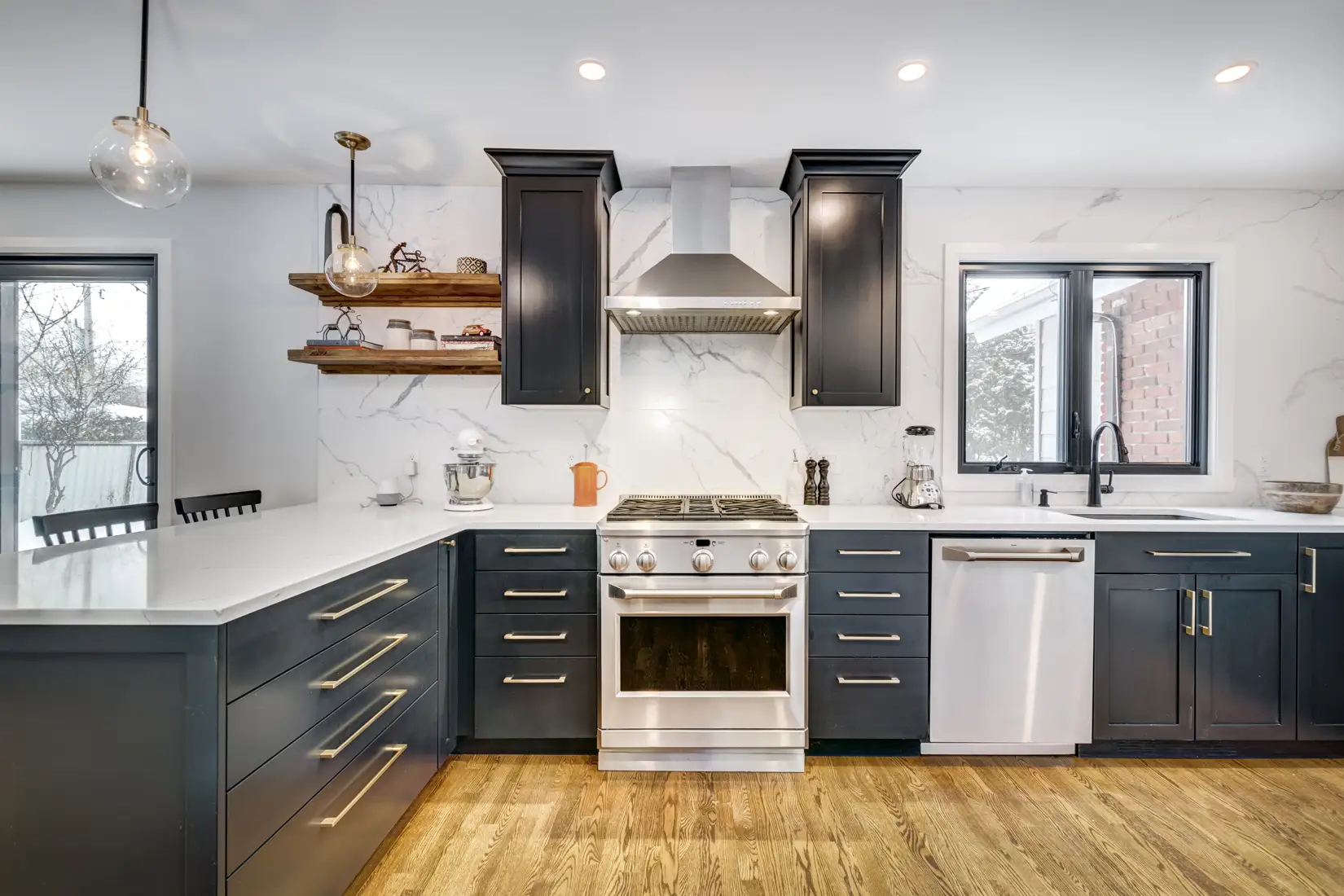 Modern kitchen with navy blue cabinets and white stone countertops.