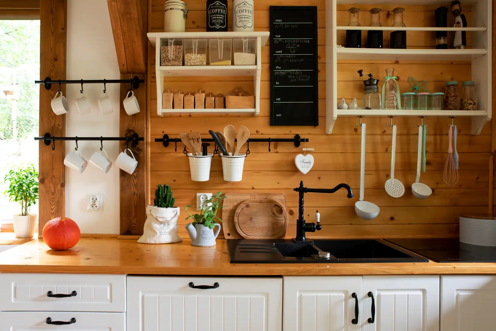 Cottage kitchen with beadboard cabinets and wood plank backsplash.