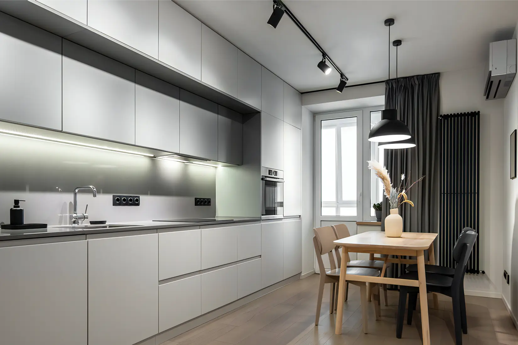 A modern gray kitchen with track and pendant lights.