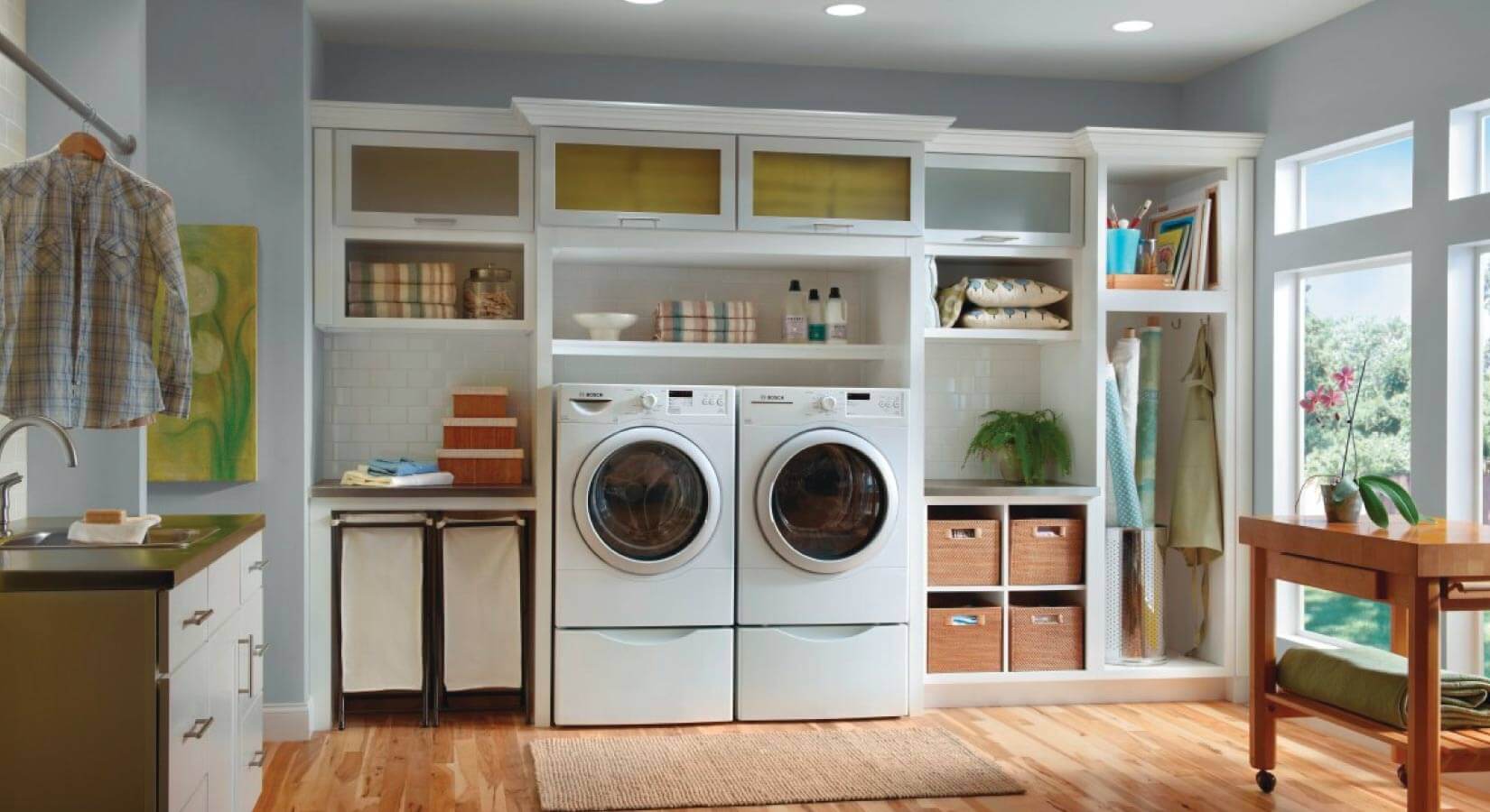 Laundry room with white appliances in a white open shelving unit with frosted glass cabinets on top.