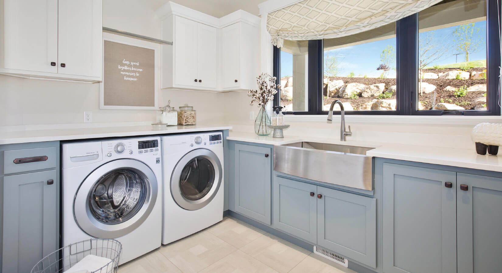 Large laundry room with white upper cabinets, blue lower cabinets, and white appliances.