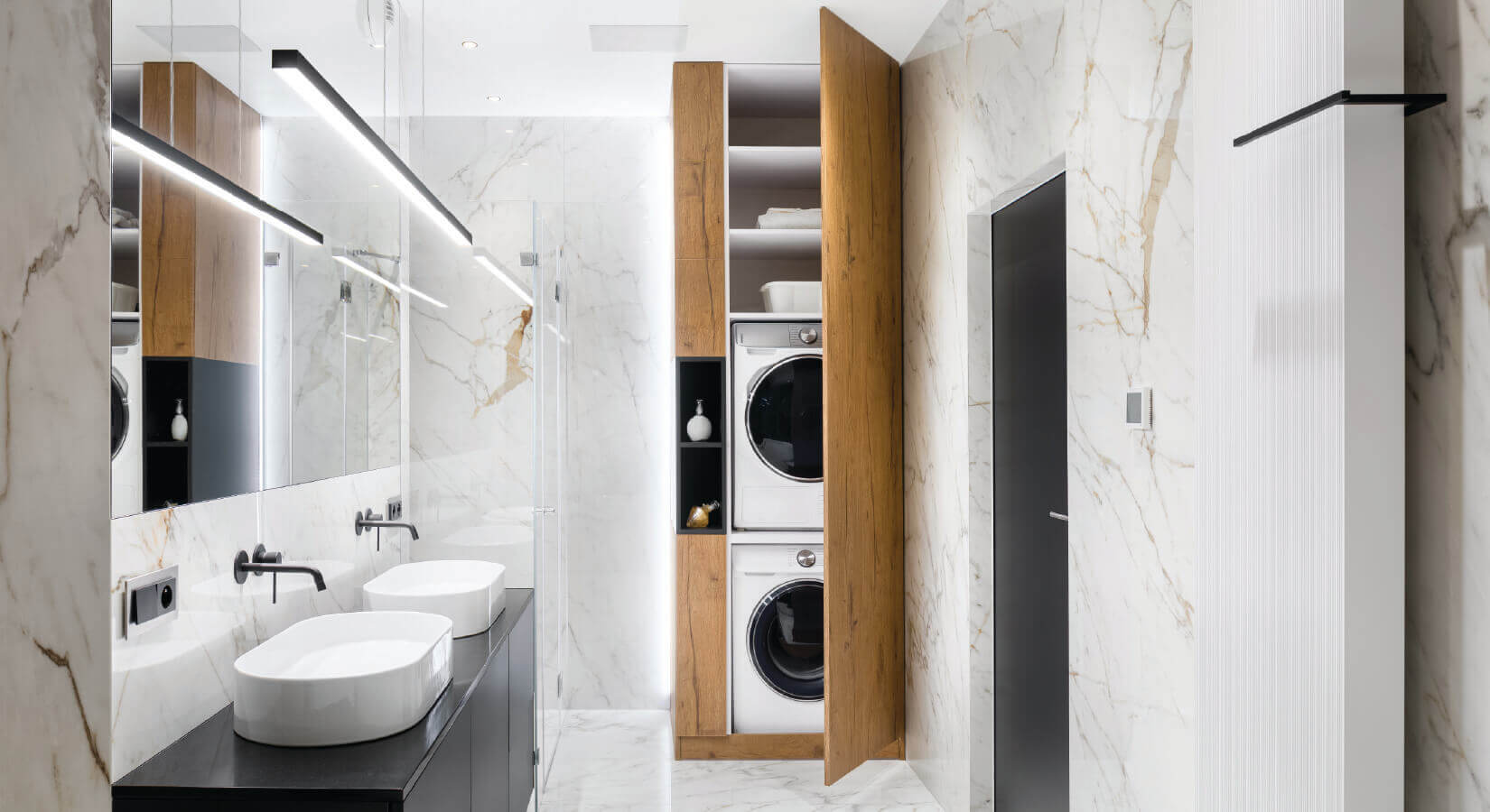 Modern bathroom with laundry appliances stacked in floor-to-ceiling cabinet.