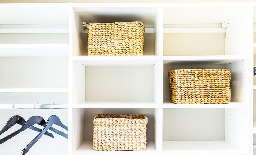 White open shelves with three wicker baskets.