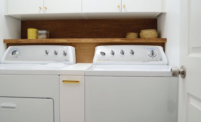 A white washer and dryer unit with small pull-out cabinet in between.