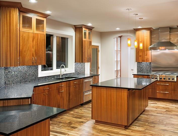 Brown glazed maple wood cabinets with black countertops.