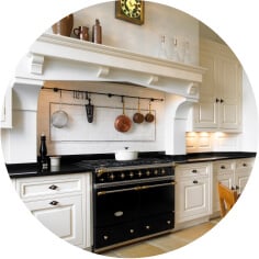 Ivory maple wood kitchen cabinets with black countertops.