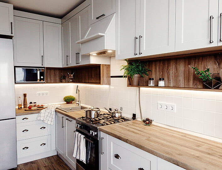 Modern farmhouse kitchen with white MDF shaker cabinets, light butcher block countertops and white, square tile backsplash.