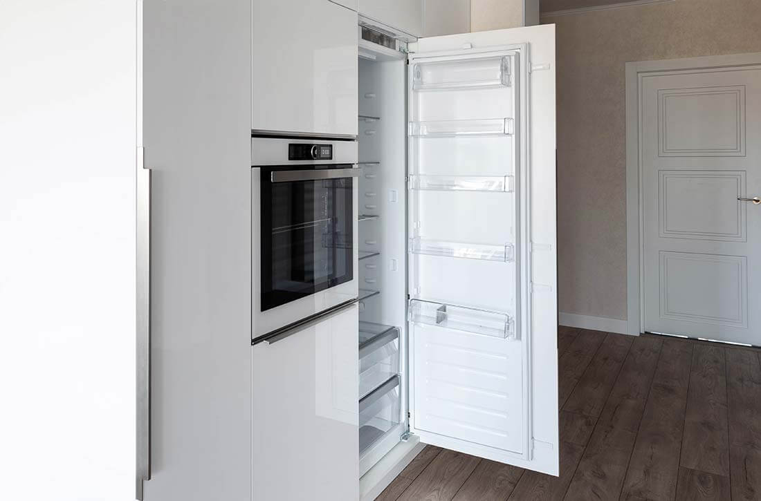 Integrated refrigerator in white kitchen.
