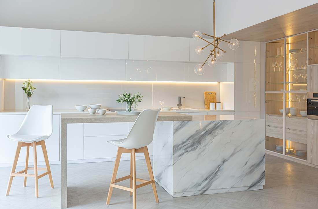 Marble island in sleek white kitchen.