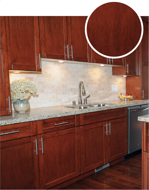 Cherry oak cabinets with a light stone backsplash and light granite countertops.