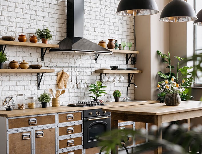 Rustic, industrial kitchen with wood shelves attached to white brick wall with steel brackets.
