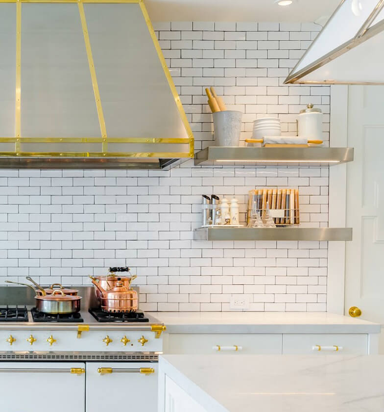 White contemporary kitchen with gold accents and stainless steel open shelving.
