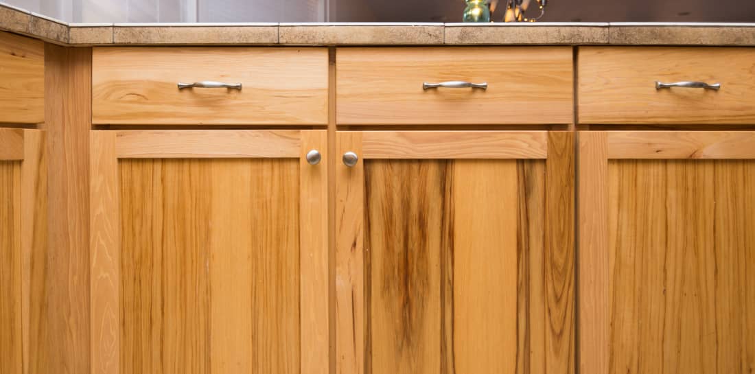 Closeup of walnut stained kitchen cabinets.