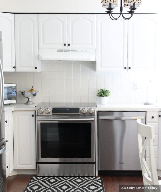 White painted kitchen cabinets with white tile backsplash