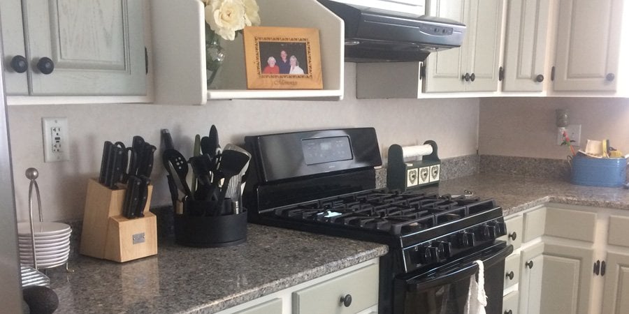 Green painted cabinets with black appliances