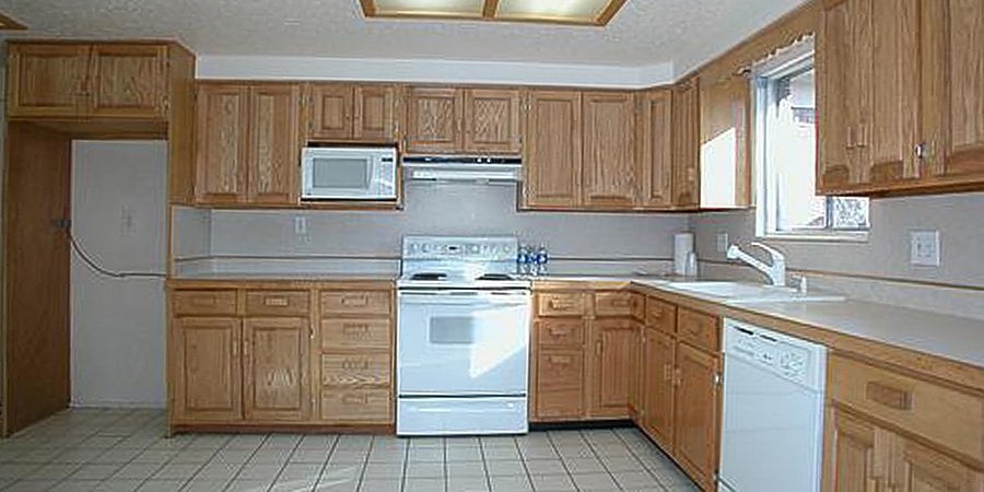 Wood kitchen cabinets with white appliances