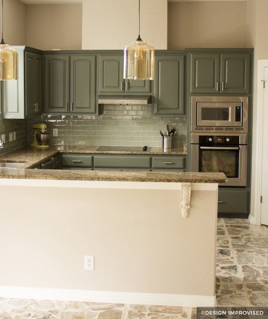 Green painted kitchen cabinets with teal backsplash