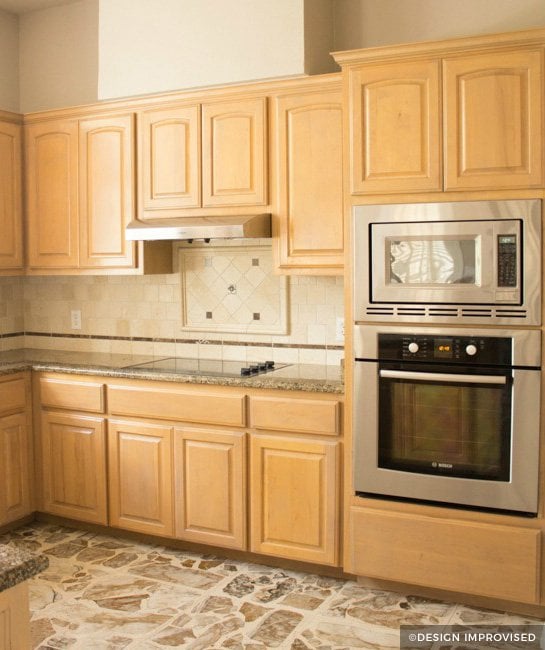 Wood cabinets with natural tile backsplash