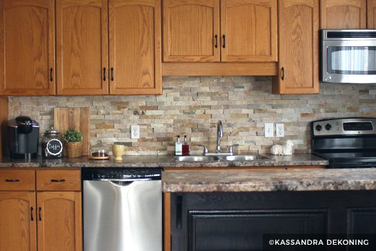 Wood cabinets with stone tile backsplash