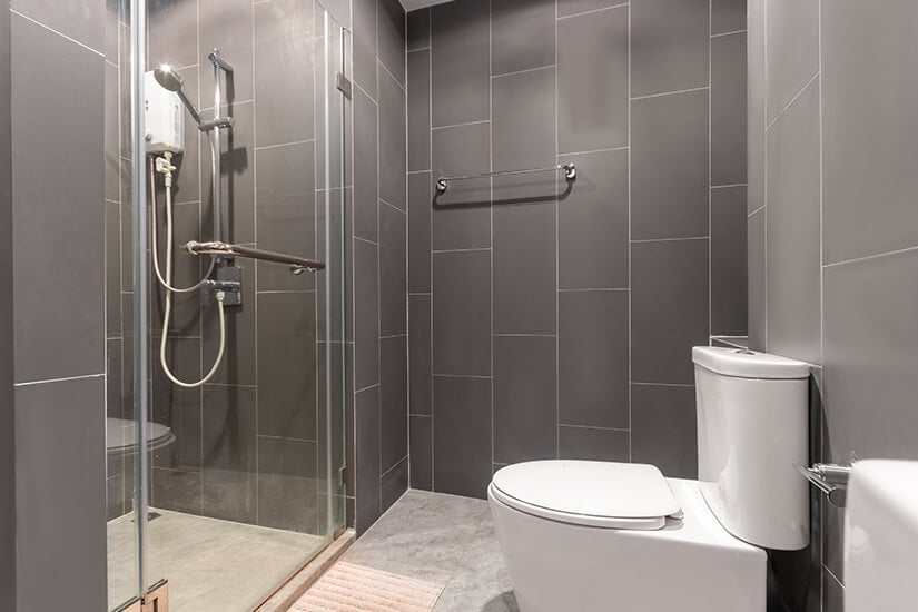 Small bathroom with large gray vertical wall tiles.