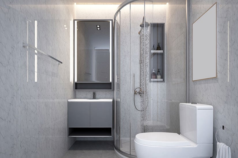 Small bathroom with marble walls and curved corner shower.