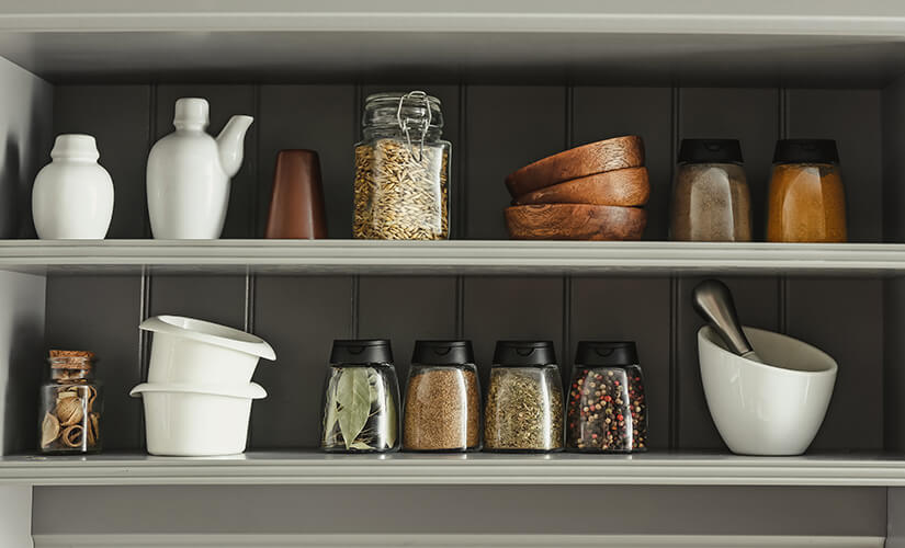 Spices stored in mis-matched jars on open shelves.