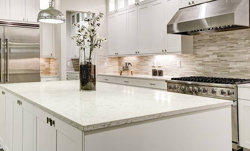 Transitional kitchen design with white cabinets and stone countertops.