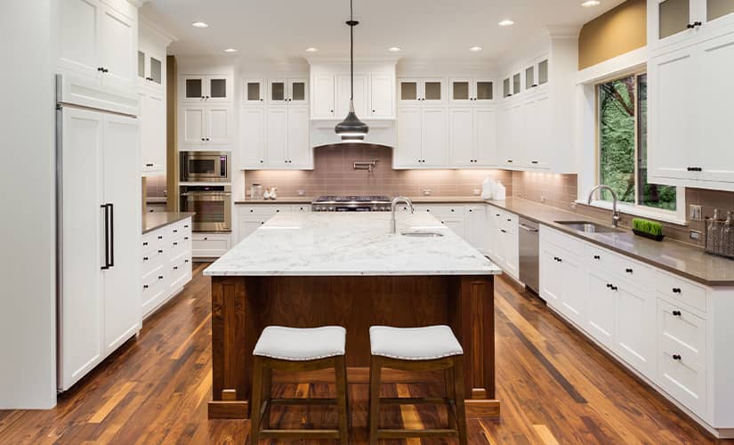 Transitional kitchen with white cabinets and two-tone stone countertops.