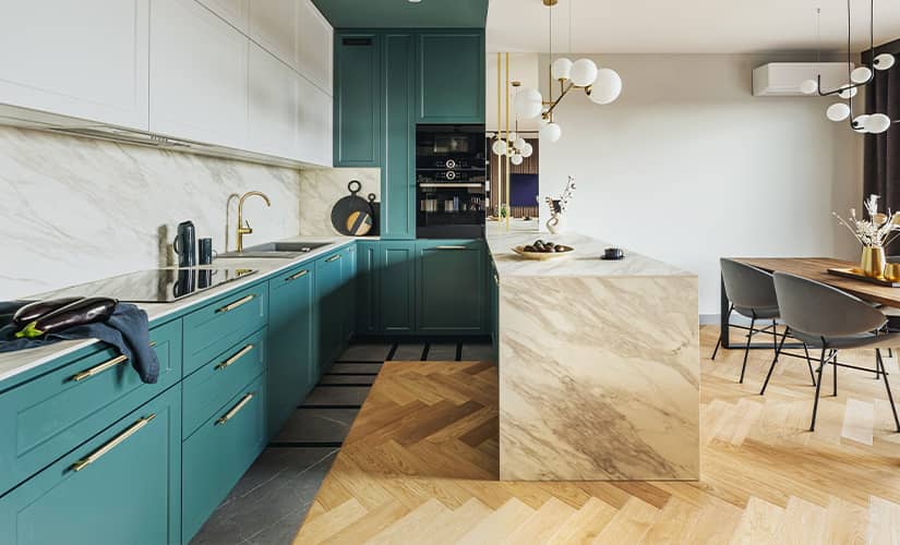 Transitional style kitchen with teal cabinets and herringbone wood flooring.