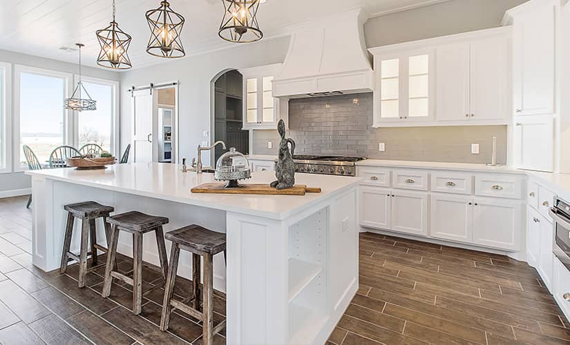 All-white transitional kitchen with wood plank flooring.