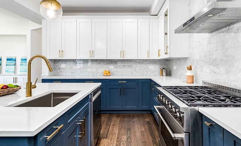 Transitional style kitchen two-tone navy and white shaker cabinets.