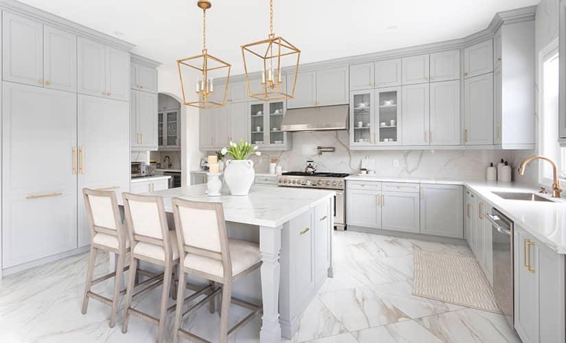 Transitional style kitchen with white cabinets brass light fixtures and hardware.