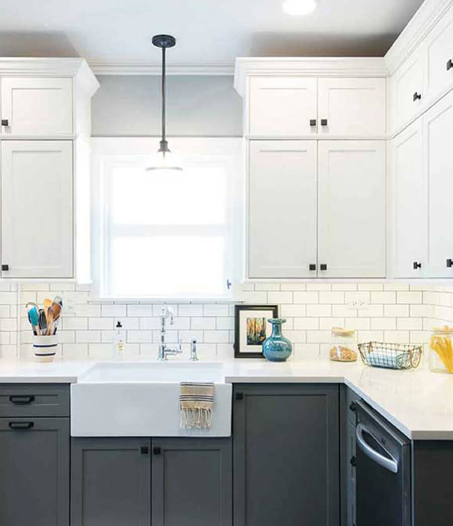 Two tone kitchen cabinets with dark grout.