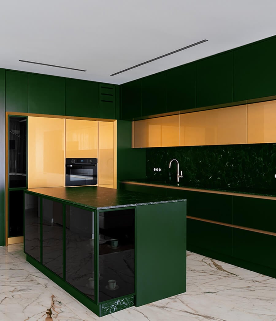 Two-tone kitchen cabinets with green and gold.