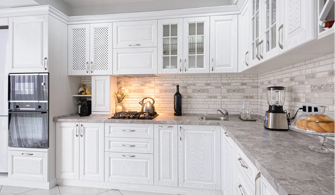 Traditional kitchen with white raised panel kitchen cabinets.