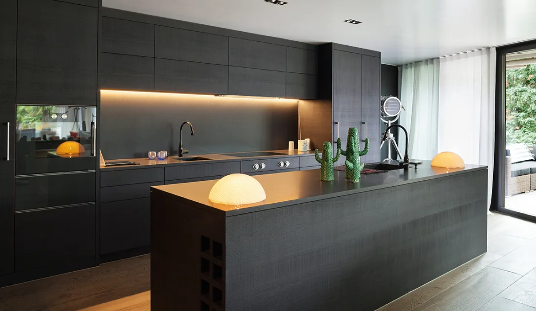 All black kitchen with floor-to-ceiling cabinets.