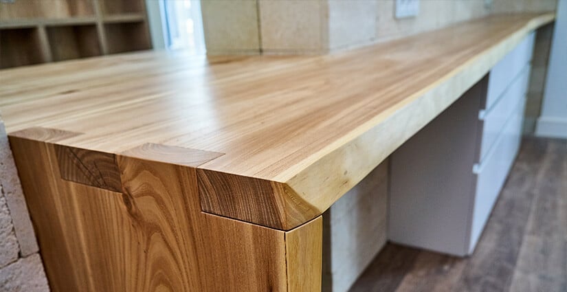 Close up of light wood countertop with live edge.